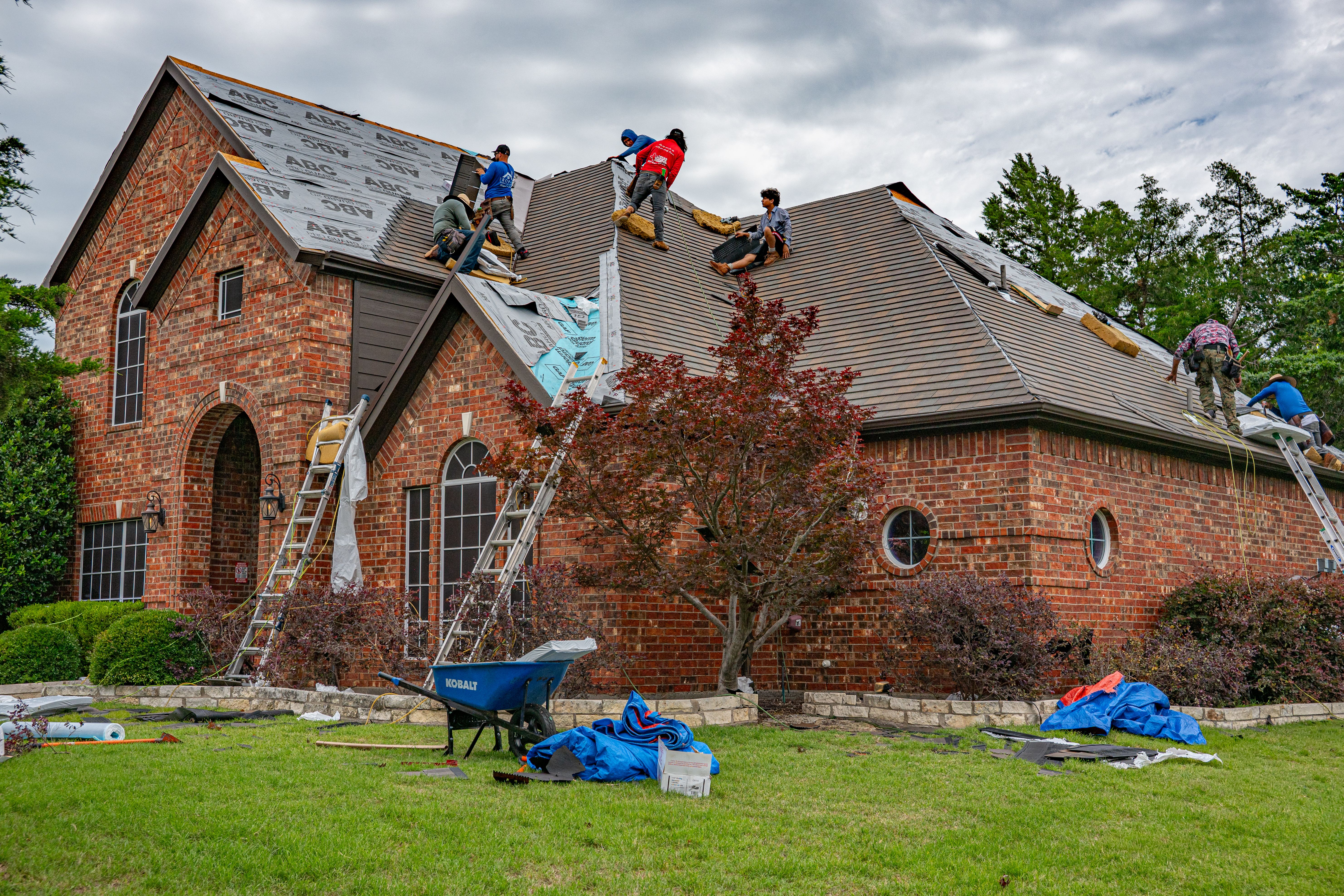 Roofers laying shingles on a new roof